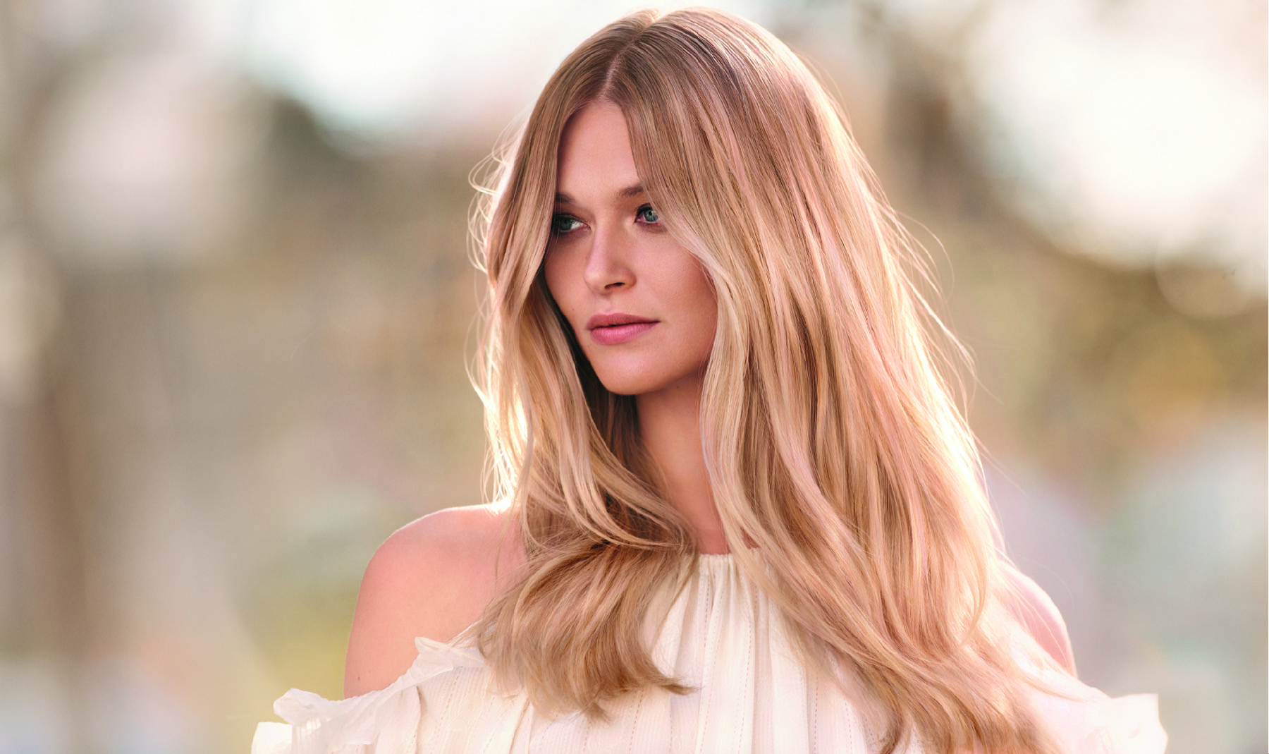 Vrouw met warme, glanzende blonde golven — hairstyling bij Studio 23